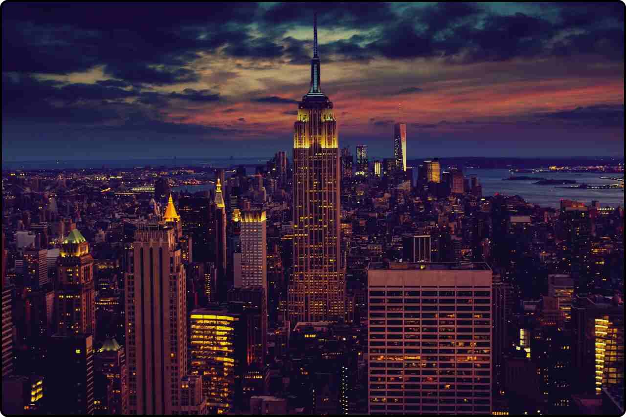 Tall buildings in New York City glowing under the evening lights.